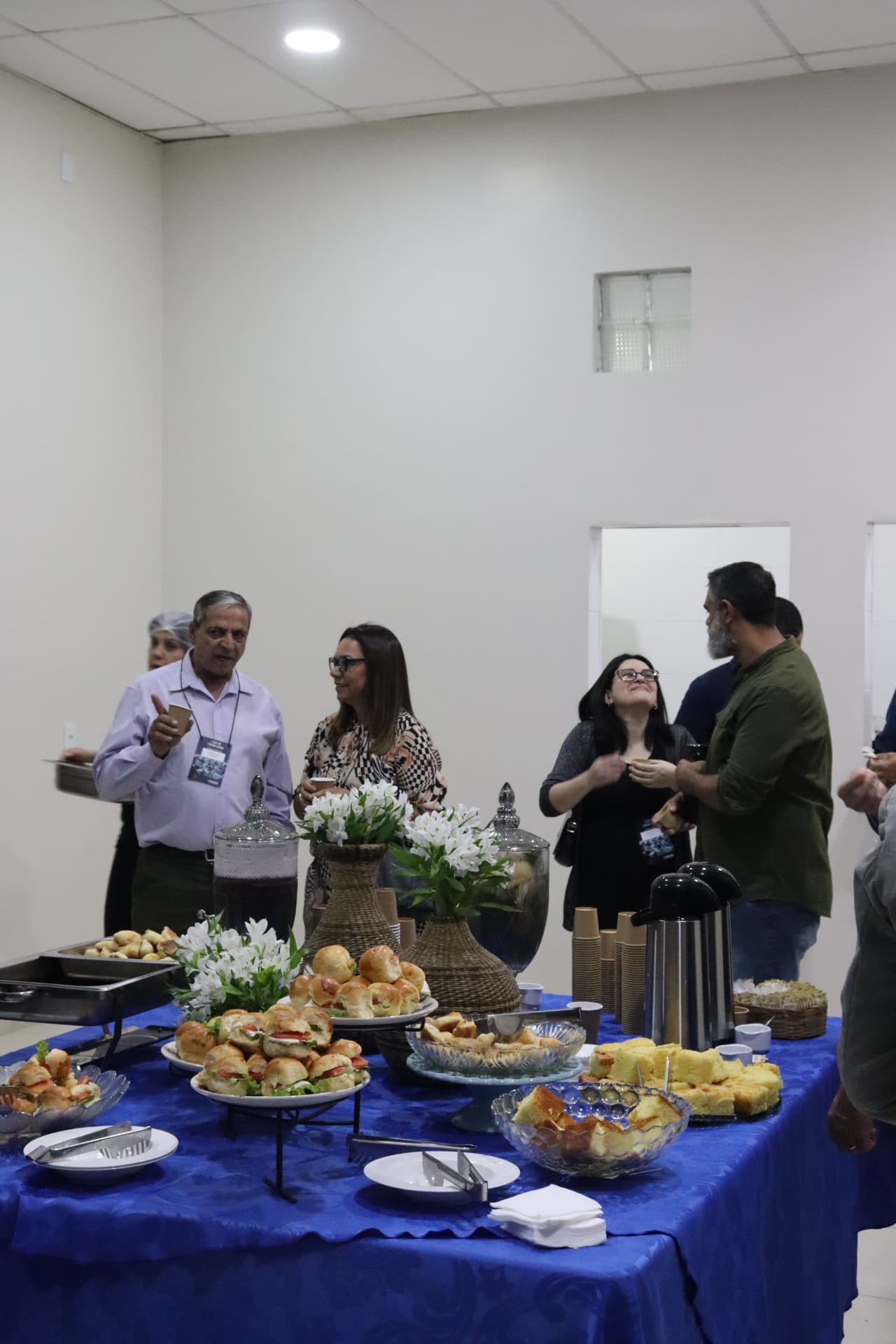 Empresários se servindo e conversando no salão da IBCS